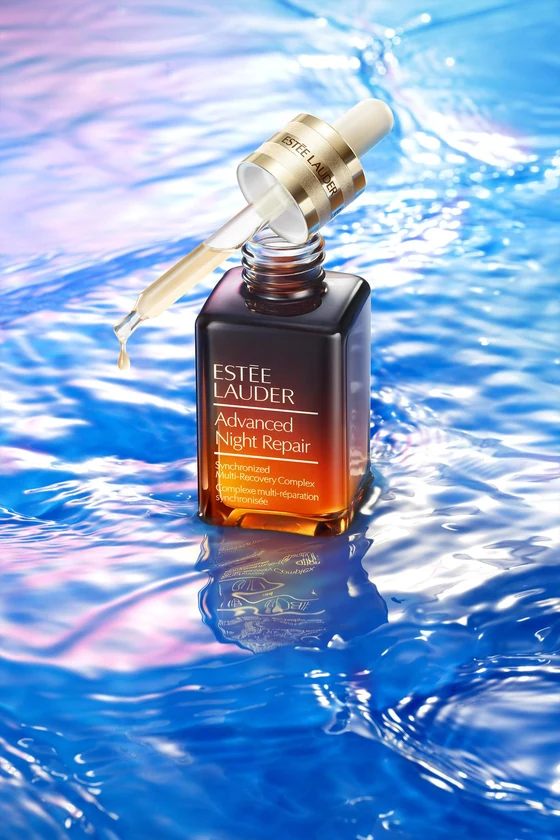 Concept beauty: flacone di prodotto su una superficie d’acqua blu